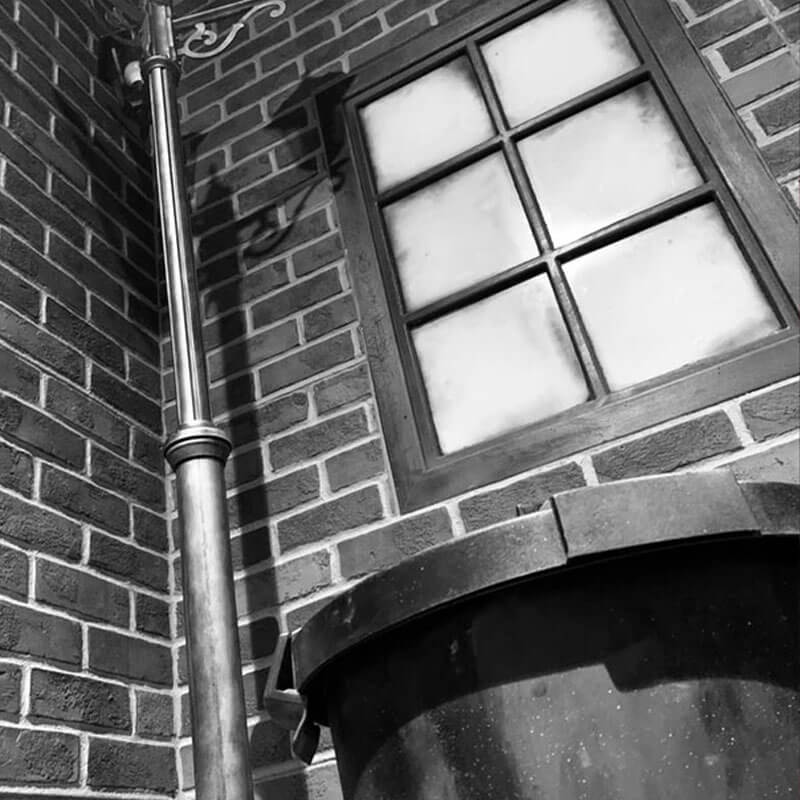 black and white photo of a street light next to a window and a trashcan 1